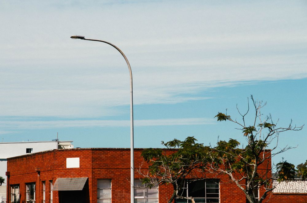 Street Lamp And Red Brick Building Against A Bright Blue Sky
