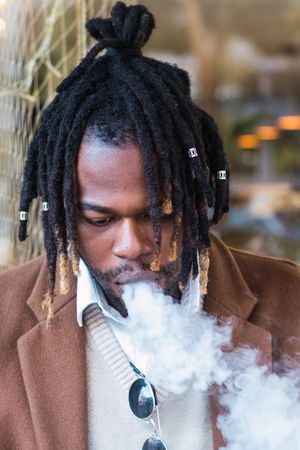 Hipster Black man with electronic cigarette on the street