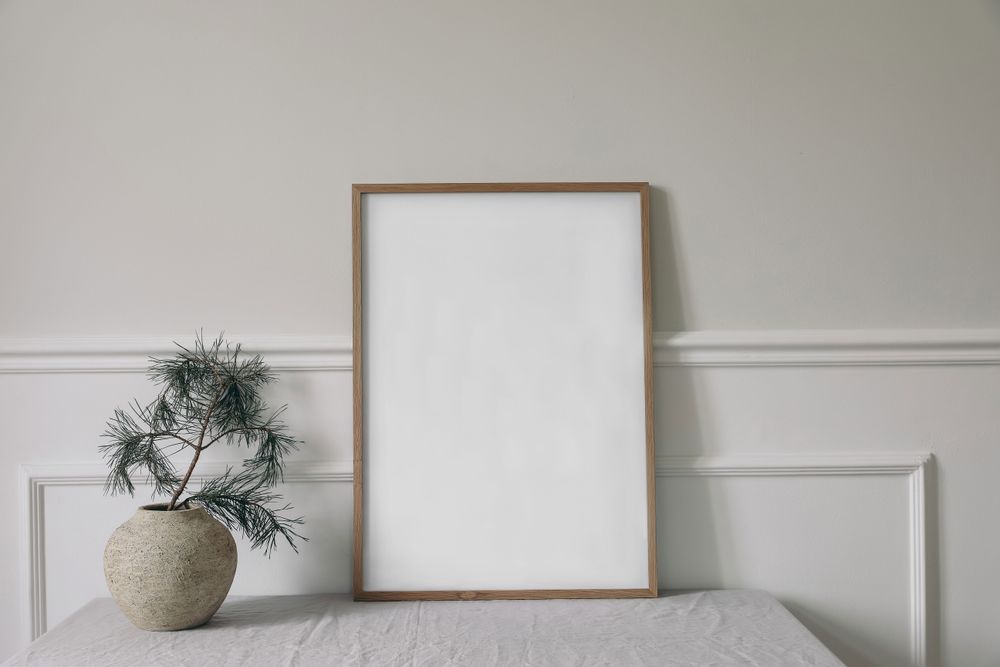 Front view of blank vertical wooden picture frame, poster mockup with pine tree branches in old vase
