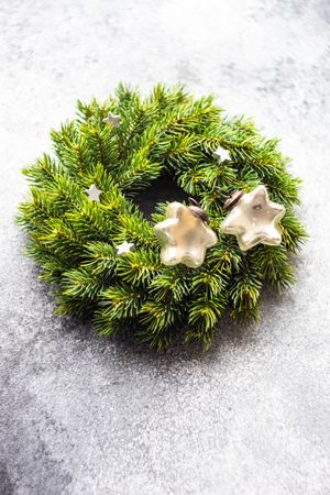Christmas wreath with decorative stars on marble background, vertical composition