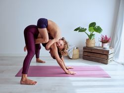 Mother and son embracing while doing acro yoga at home