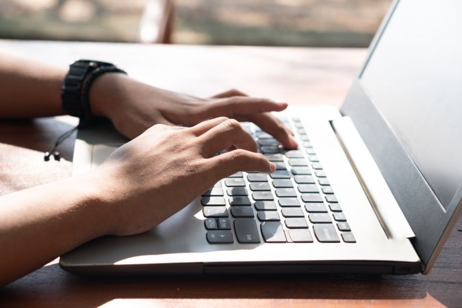 Closeup Asian Young businessman work at outdoor with laptop. Concept of remote and freelance work. Young successful man wearing casual blue cloth.