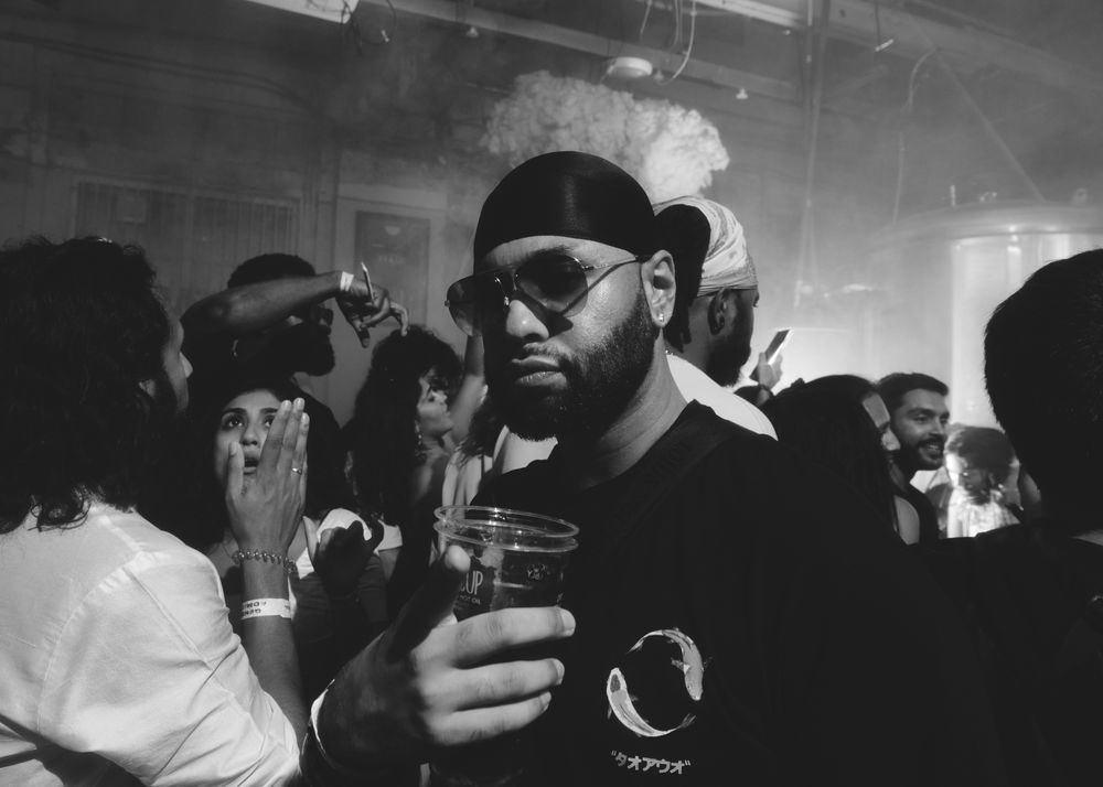 London, England, United Kingdom - Nov 9, 2022: B&W portrait of man with drink in crowd