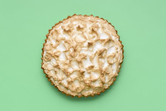 Lemon meringue pie above view on a green background