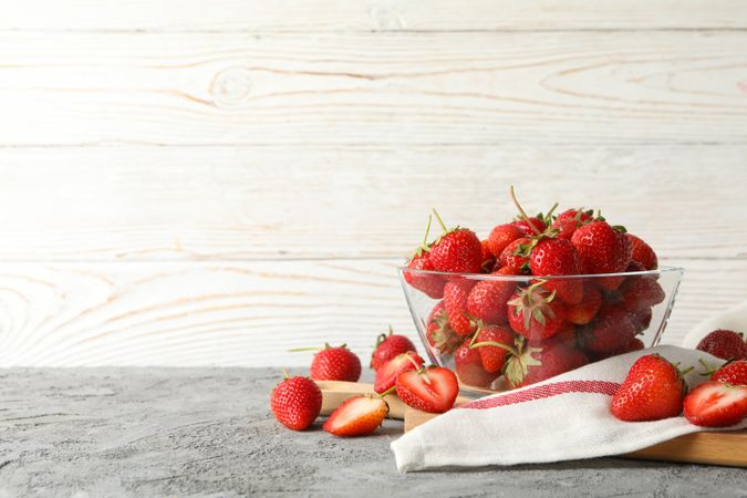 Composition with bowl of tasty strawberry on gray table. Summer berry
