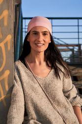 Happy woman in pink scarf of breast cancer community