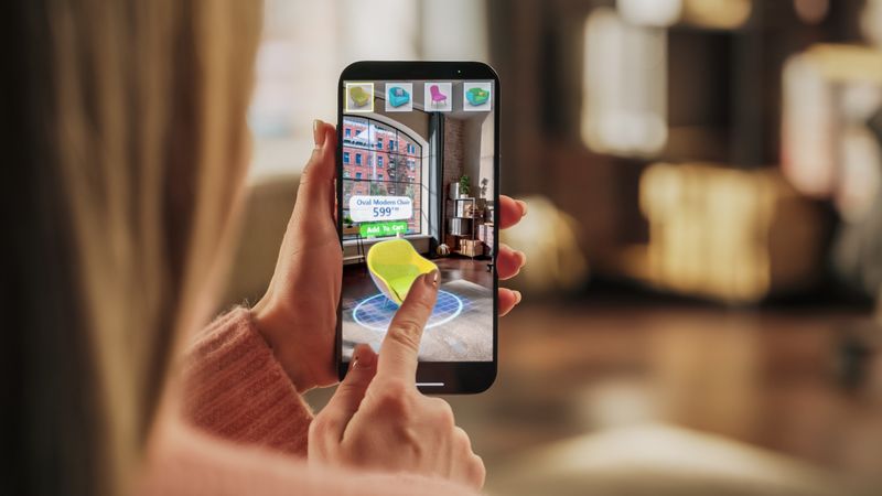 Decorating Apartment: Woman Holding Smartphone, using Augmented Reality Interior Design Software Chooses 3D Furniture for Home.