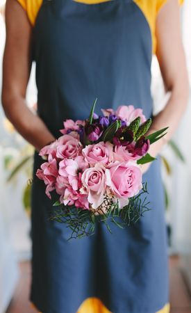 Female florist holding mixed flower bouquet in hand
