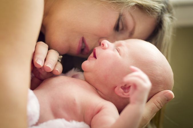 Young Mother Holding Her New Newborn Baby Girl