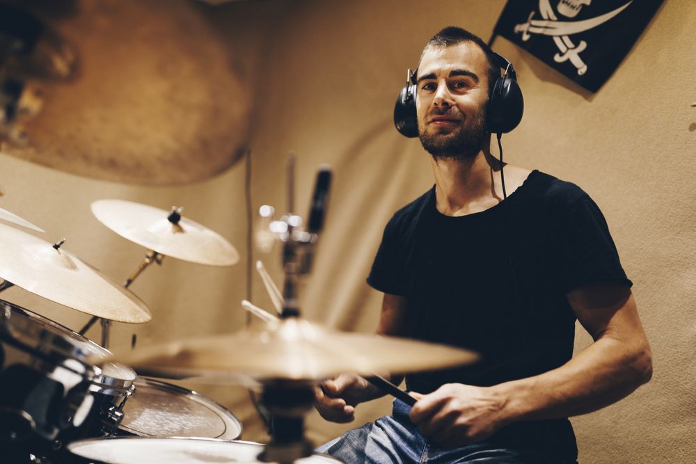 Man with headphones playing on drums