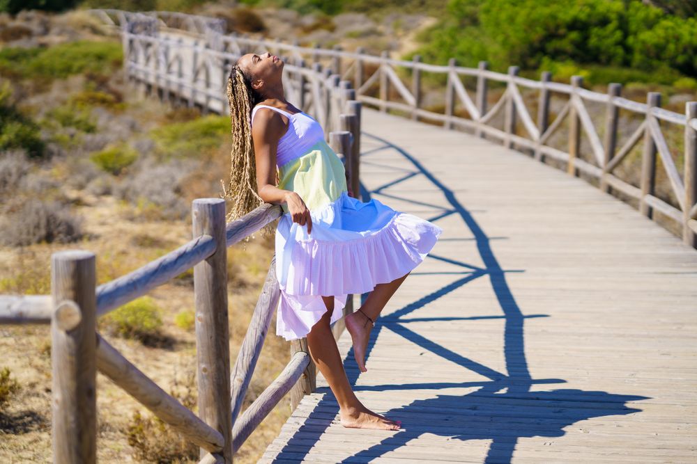 Female leaning with head back on a pedestrian walkway in colorful dress