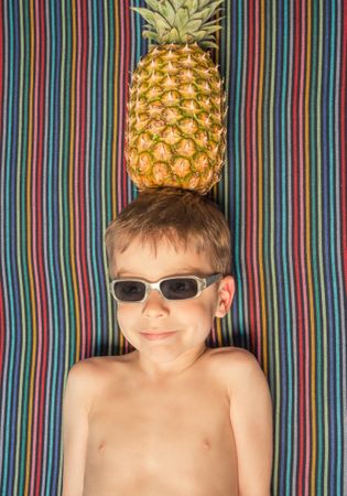 Happy child with sunglasses and pineapple in head