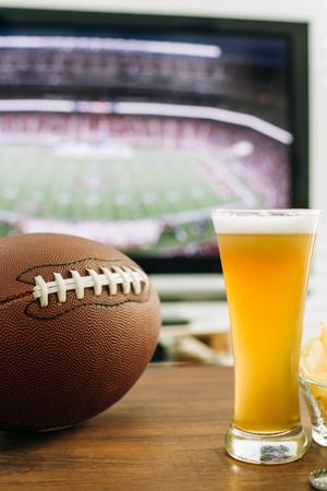 Beer and snacks prepared for watching american football on TV