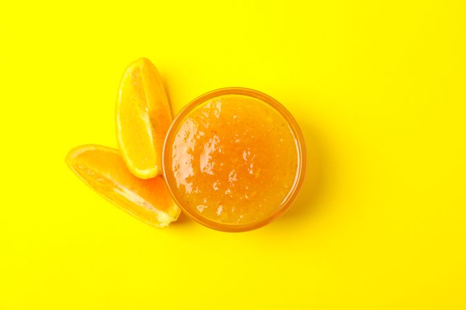 Delicious orange jam on yellow background, top view