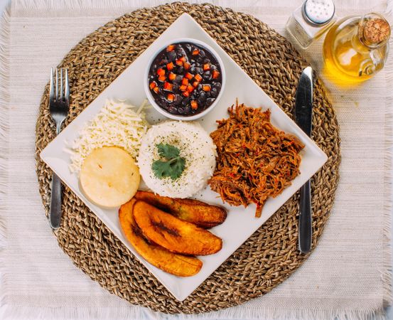 Homemade Venezuelan food. Traditional Venezuelan dish. Pabellon Criollo. White Rice, beans, Fried plantains, and Shredded beef