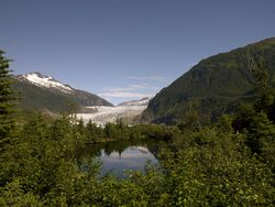 Mendenhall Glacier in Alaska behind lush green forest lake B5ajG4