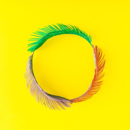 Painted tropical and palm leaves in vibrant bold colors on yellow background