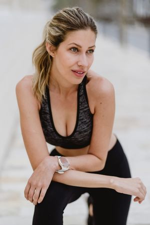 Satisfied sportswoman in active clothing smiling while exercising