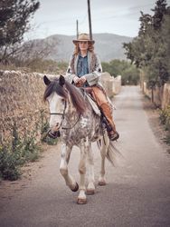 Woman riding horse in countryside