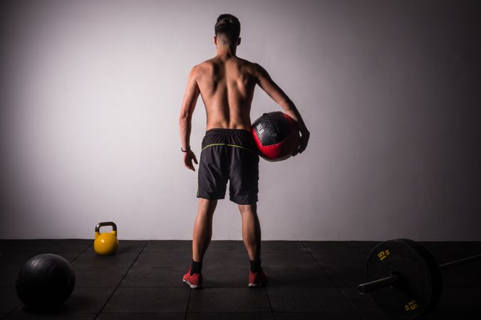 Man throwing ball on wall in gym