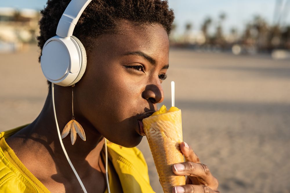 Cool female eating ice cream on beach