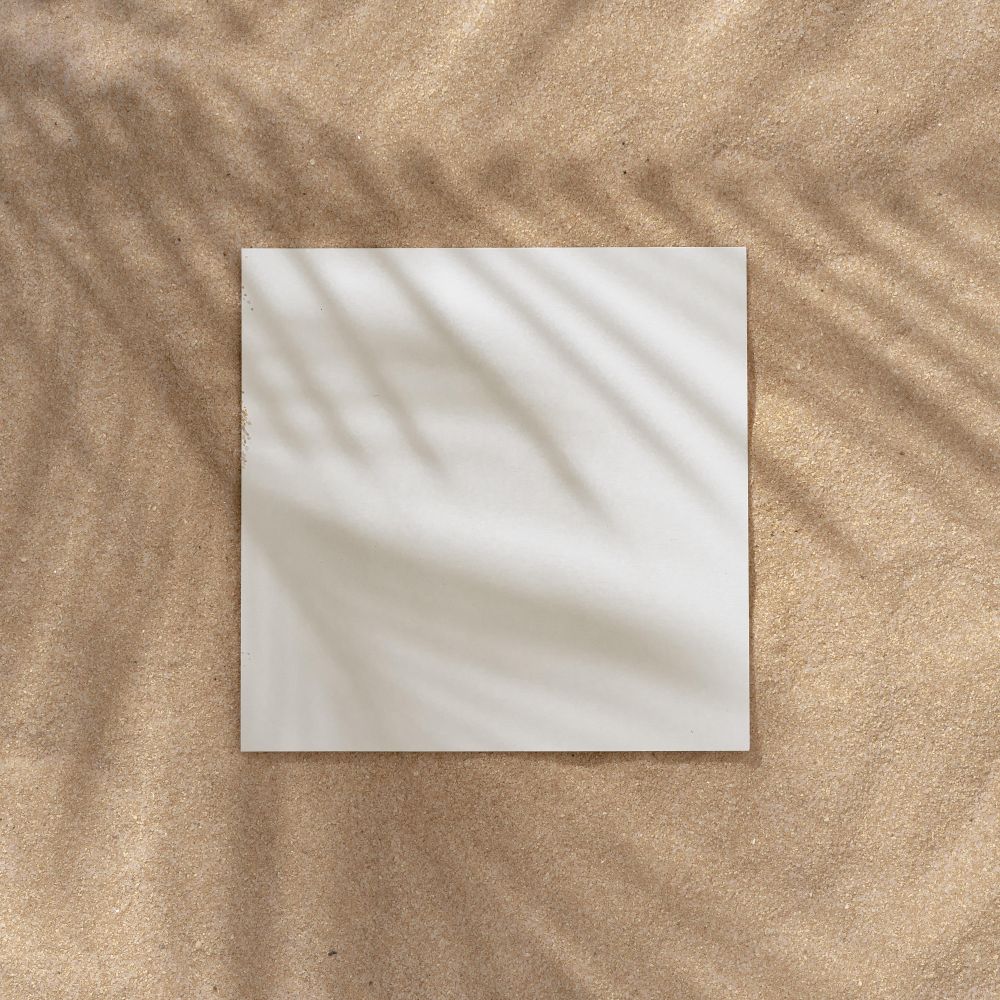 Sand with palm leaf shadows and central square