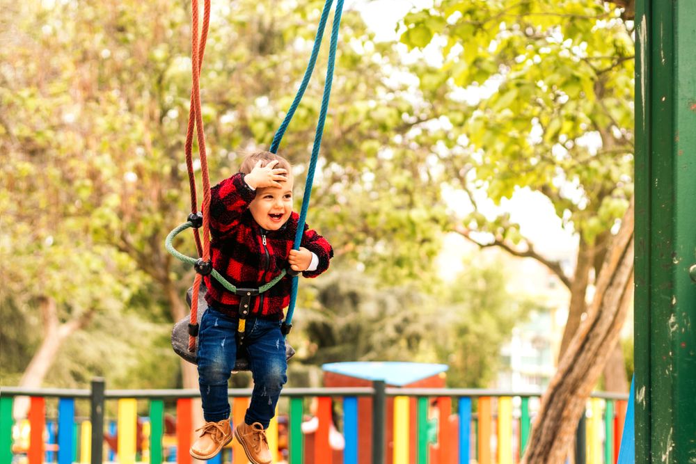 cute baby having fun on a swing in a playground