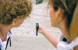Older woman looking smart watch with her coach