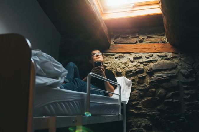Woman in dorm bed with skylight