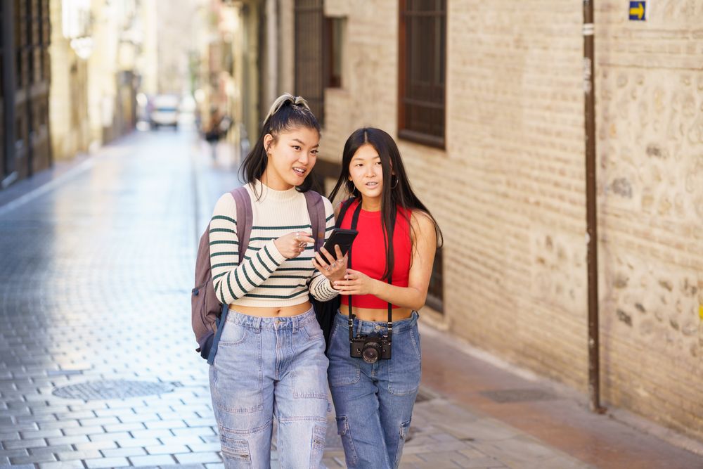 Two women walking along quiet Spanish street