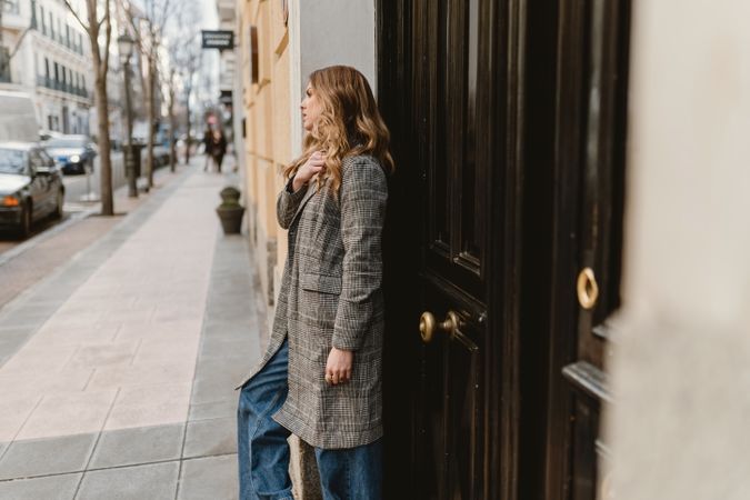 Woman leaning on wall on street