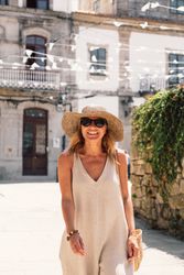 Woman in hat walking along sunny street