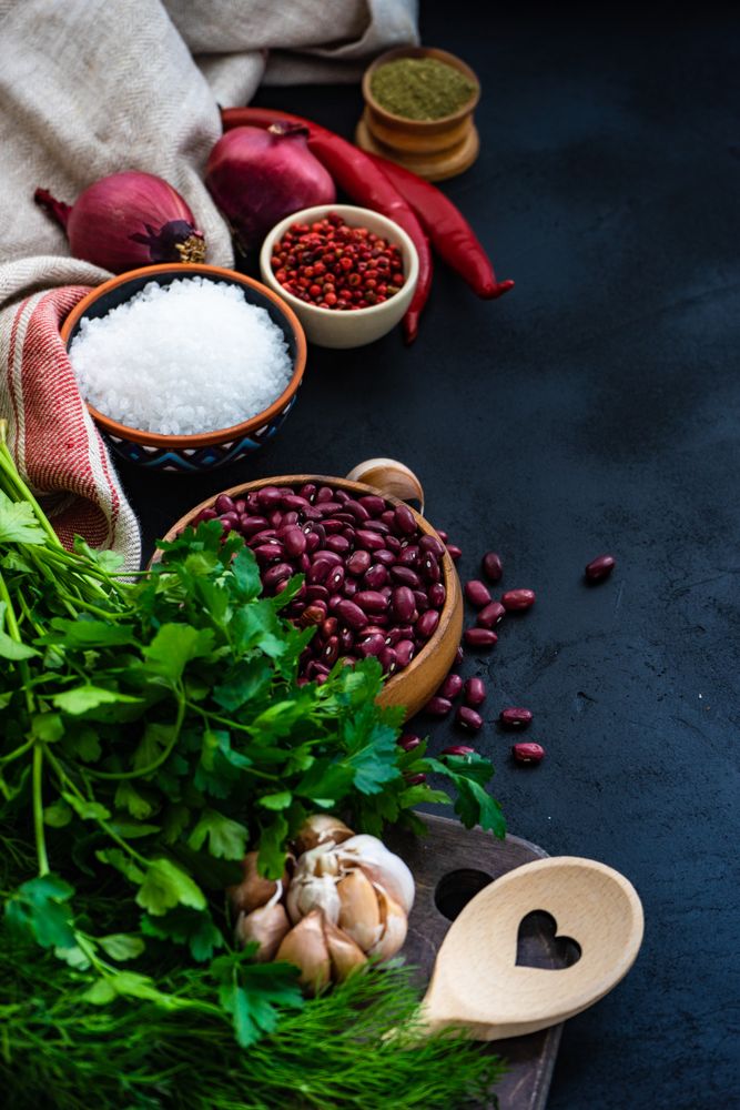Counter of kitchen with bowl of dried kidney beans, herbs and seasoning