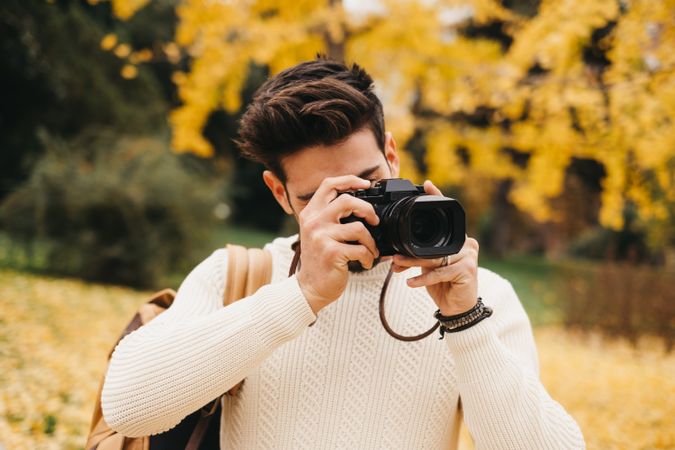 Trendy male with backpack and camera