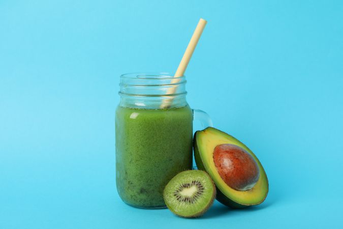 Smoothie, avocado and kiwi on blue background