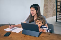 Mother and son using laptop at home