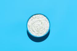Tzatziki sauce bowl top view on a blue background