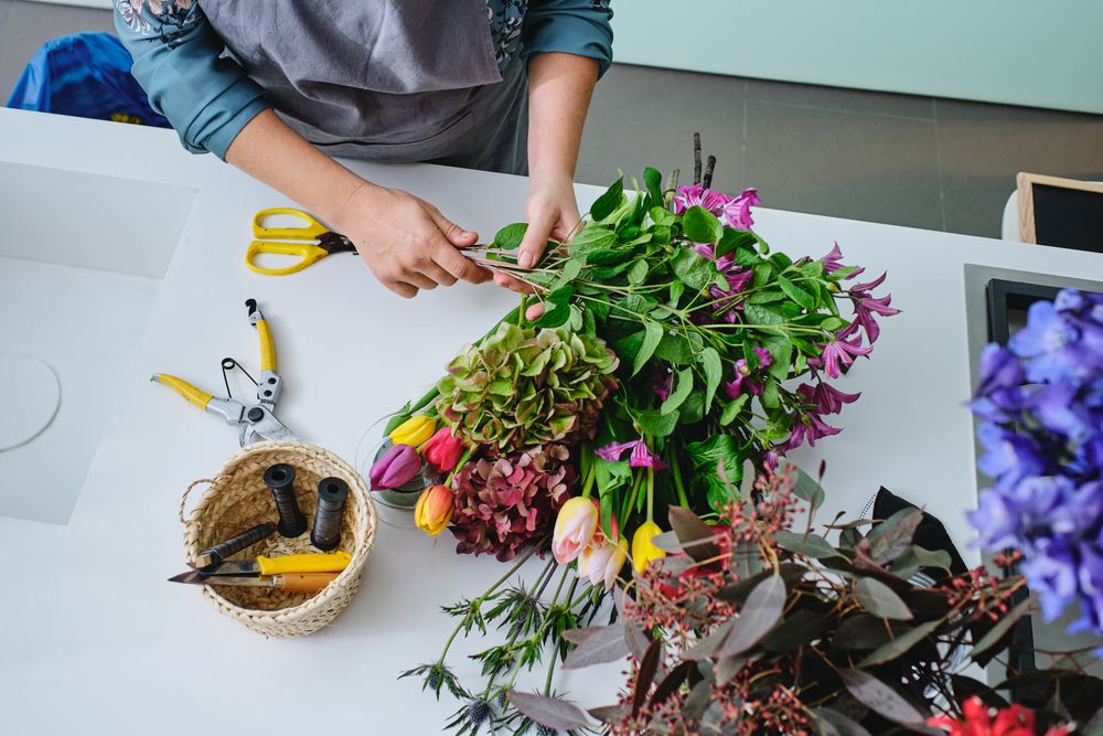 Unrecognizable female florist arranging bouquet of flowers