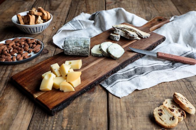 Croutons and nuts near board with cheese