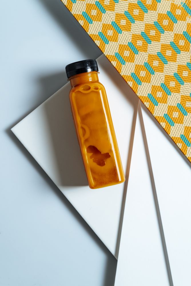 Mango and pumpkin smoothie bottle over retro textures