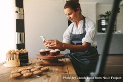 Female baker capturing photos of pastry items with her cell phone 5ljgMb