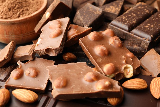 Chocolate, melted chocolate and almond on dark background