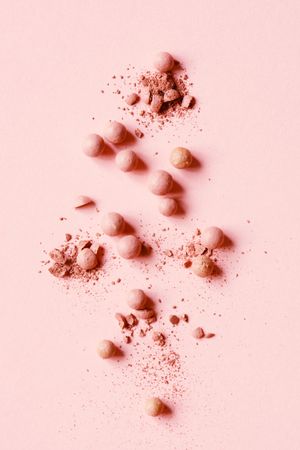 Powdered balls of pink makeup on pink background