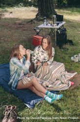 Woman drinking water with friend in campsite 4OdjQR