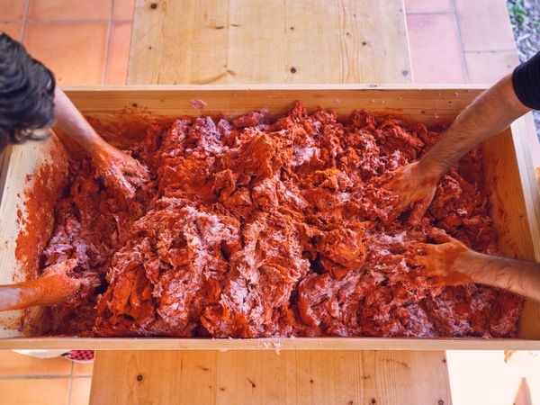 Crop men mixing minced meat with salt and spices