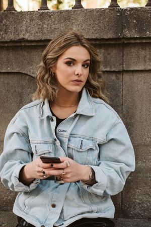 Woman using smartphone near park fence