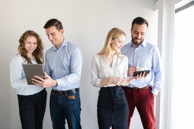 Men and women with gadgets in office