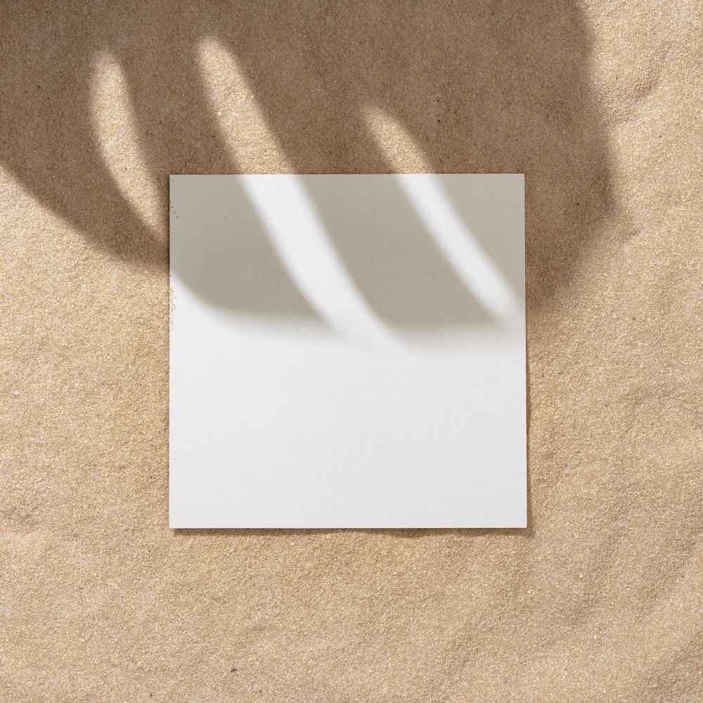 Sand with palm leaf shadows and central square