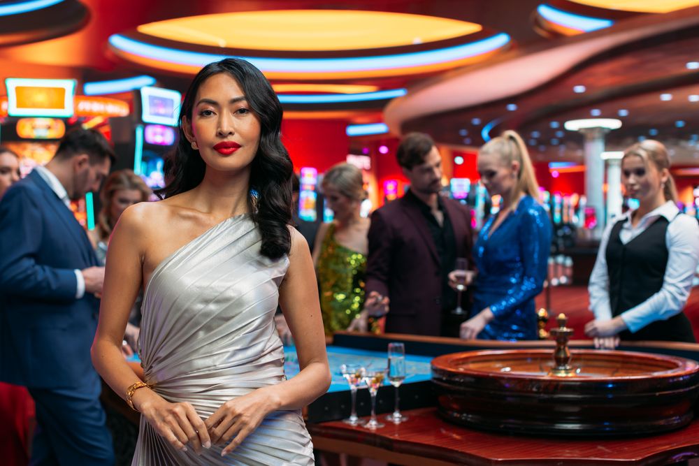 Asian Woman, Wearing an Elegant Silver Dress, Striking Different Modeling Poses in a Glamorous Atmosphere of a Casino