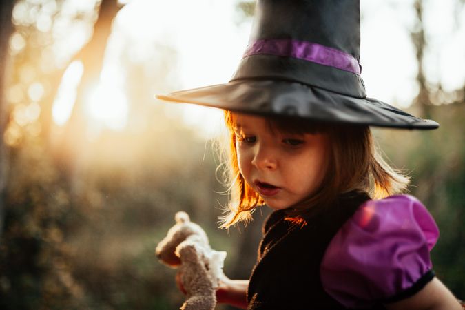 Young girl in witch costume in the forest